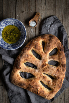 Baked fougasse bread on table with salt and oil