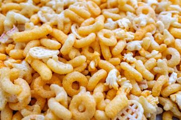 Detail of a snack based on flavored cheese puff, with corn flour and hydrogenated fats.