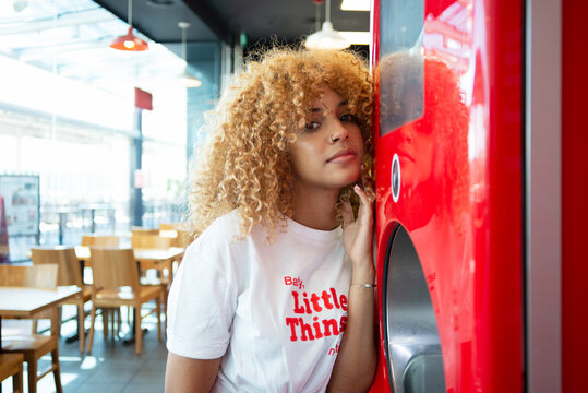 Black woman standing near soda machine in cafe