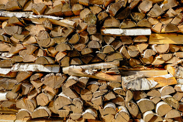 Background of dry chopped wood stacked against the wall