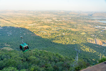 Fototapeta premium Aerial view of cable car ride in Johannesburg Africa with mountains and tropical forest background. Tourist attraction advertisement brochure, people leisure concept.