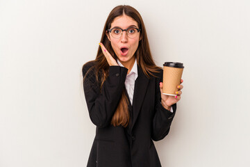 Young caucasian business woman holding a takeaway coffee isolated on white background surprised and shocked.