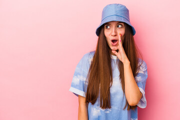 Fototapeta premium Young caucasian woman isolated on pink background is saying a secret hot braking news and looking aside