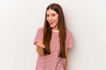 Young caucasian woman isolated on white background stretching hand at camera in greeting gesture.