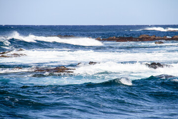sea landscape, blue sea waves crashing against the rocks, big turquoise wave in the ocean