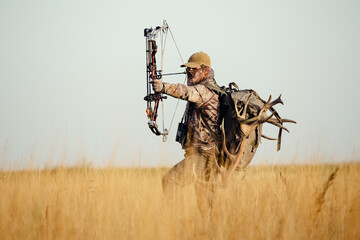 Archery hunter with his bow drawn back ready for a shot