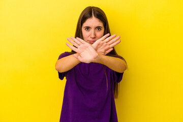 Young caucasian woman isolated on yellow background doing a denial gesture