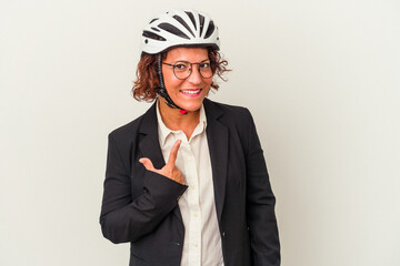 Middle age latin business woman wearing a bike helmet isolated on white background pointing with finger at you as if inviting come closer.