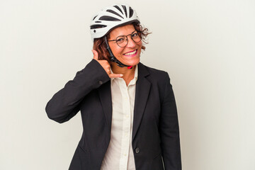 Middle age latin business woman wearing a bike helmet isolated on white background showing a mobile phone call gesture with fingers.
