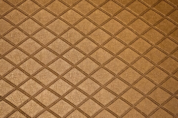 golden leather texture on sofa or brown fabric and blank wood wall or top view empty table with grid and diamond or square pattern for background or wallpaper