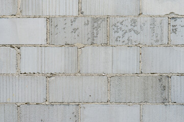 A wall made of concrete blocks and cement joints