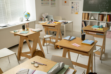 Group of workplaces of secondary schoolchildren in large classroom
