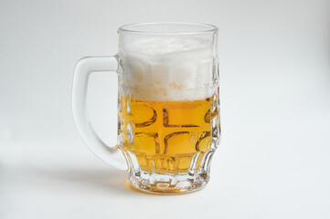 Mug of beer with foam on white background