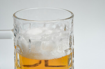 Mug of beer with foam on white background