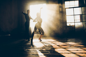 Couple of two professional ballroom dancers is dancing on loft studio. Beautiful art performance with heavy smoke. Sport life concept. Passion and emotional dance. - obrazy, fototapety, plakaty