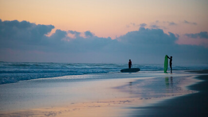 Fototapeta premium Surfer am Strand nach einer Session. Wellenreiten. Sonnenuntergang