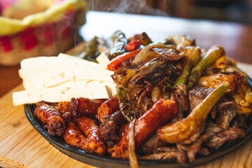 Authentic Mexican barbecue, different cuts roasted on a restaurant table. Chistorra, meat and grilled cheeses. Mexican roast beef concept