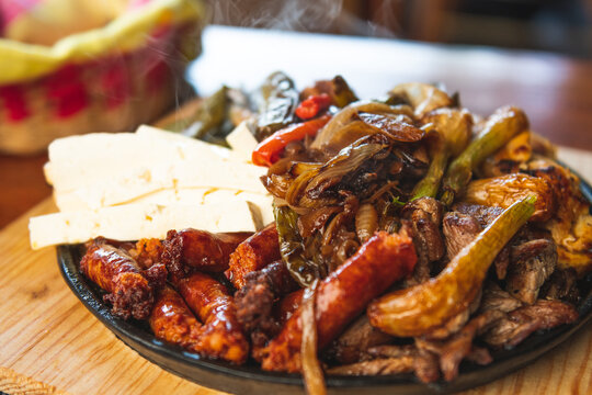 Authentic Mexican barbecue, different cuts roasted on a restaurant table. Chistorra, meat and grilled cheeses. Mexican roast beef concept
