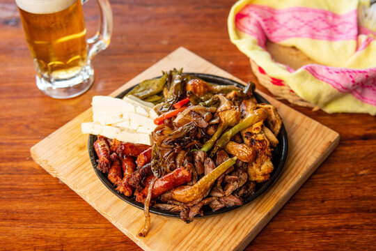 Authentic Mexican barbecue, different cuts roasted on a restaurant table. Chistorra, meat and grilled cheeses. Mexican roast beef concept