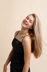 A smiling young woman on a beige background