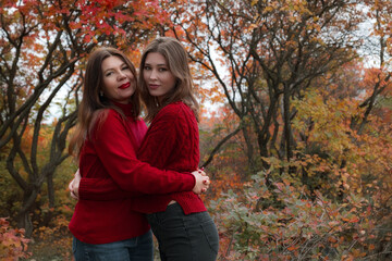 Mature mother hugging with her teen daughter outdoor in nature