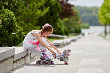 cute little girl on roller skates at park.