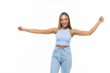 Portrait of happy caucasian woman dancing, having fun and smiling with eyes closed, hands raised up in air, white background