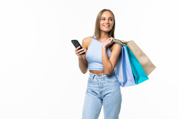 Happy shopping woman texting on her cell phone isolated over white