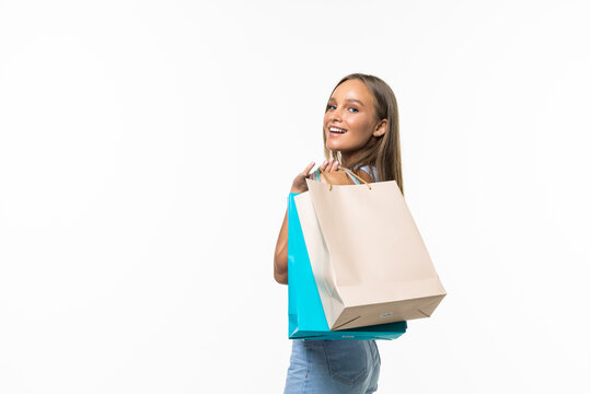 Portrait of young happy woman with shopping bags, isolated over white background