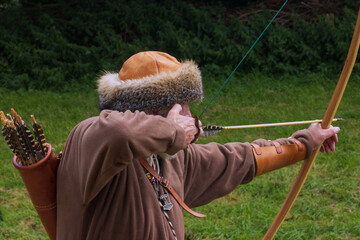 Wikinger hält ausgezogenen Eibenbogen mit aufgelegtem Pfeil , Bogenschießen, Wikinger Bogen