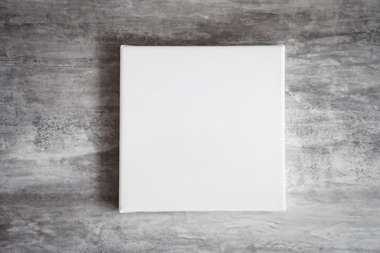 White square clean canvas for photography or drawing lies on gray wooden surface  (970)
