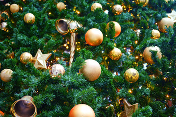 Obraz na płótnie Canvas Christmas trees with lots of golden balls, bells and yellow baubles