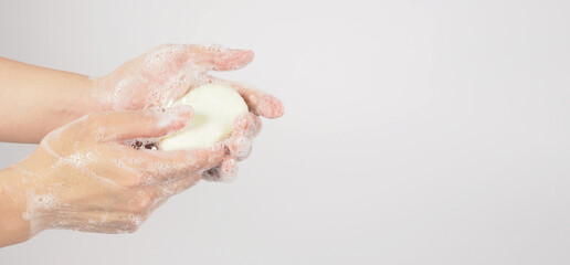 Hands washing gesture with bar soap and bubble on white background.