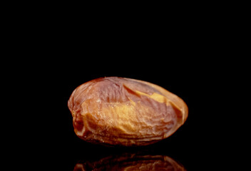 One dried organic date, close-up, isolated on black.