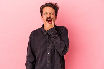 Young caucasian man isolated on pink background having a strong teeth pain, molar ache.