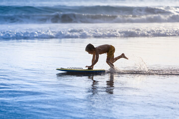 Boy with bodyboard have fun on sea beach