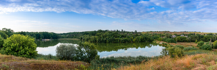 Picturesque lake among green reeds, rural landscape, panoramic shot