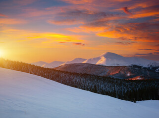 Incredible sunset in a mountain valley on a frosty evening. Image of a bright epic sky.