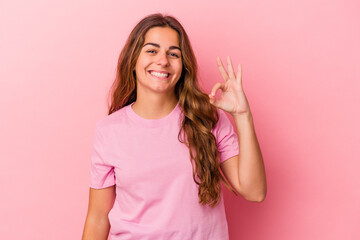 Young caucasian woman isolated on pink background  cheerful and confident showing ok gesture.