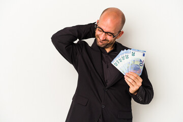 Young business bald man holding bills isolated on white background  touching back of head, thinking and making a choice.