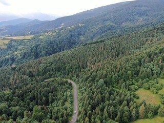 Winding road from high mountain pass, in summer time. Aerial view by drone.