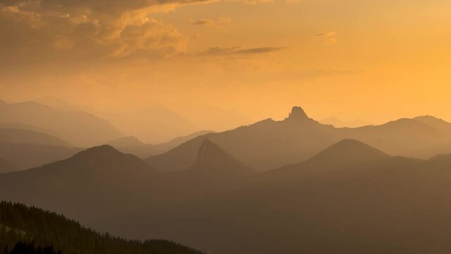 Timelapse of sun rays emerging though the dark storm clouds in the mountains. Sunset bavaria pre alps mountains germany europe forest.