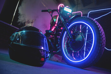 Fototapeta na wymiar Black motorcycle helmet in the neon lights. Motorbike store showroom concept.