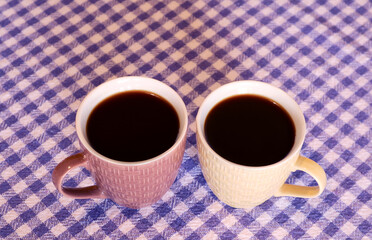 Pair of Hot Black Coffee in Ceramic Mugs on Checkers Table