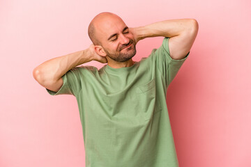 Young caucasian bald man isolated on pink background  feeling confident, with hands behind the head.