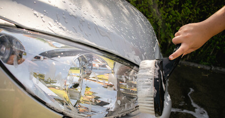 Man washing a car with a brush