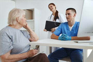 Obraz premium a nurse and a hospital doctor communicate with an elderly woman patient