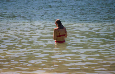 Rapariga parada a pensar dentro de água do rio - praia fluvial - biquíni vermelho - obrazy, fototapety, plakaty