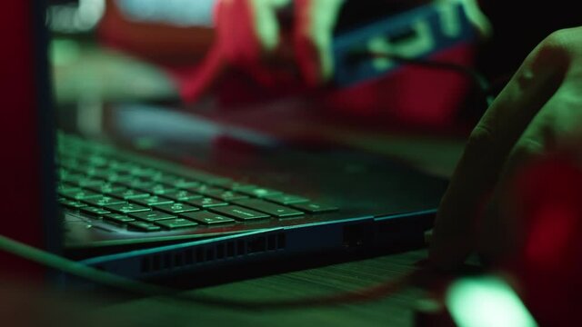 Professional hacker typing on keyboard at night, close-up of man hands trying to break password, using laptop. Developing program. Programmer infecting system with cyber virus, working on computer
