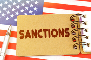 On the US flag lies a notebook with the inscription - Sanctions